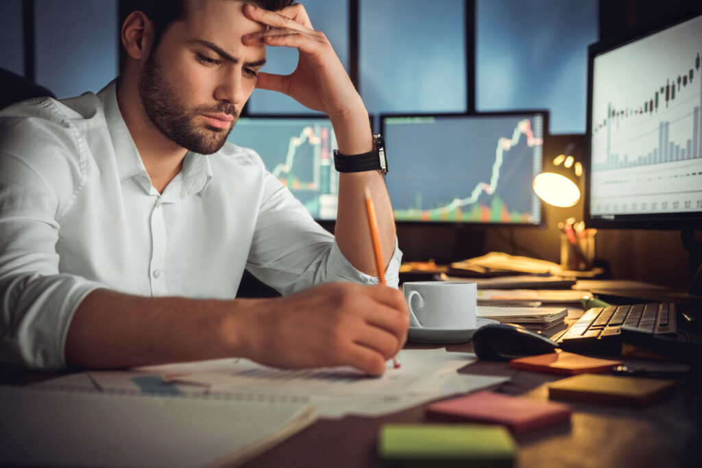 Serious businessman thinking hard about investing in a difficult market.  Invest with displince, patience and education